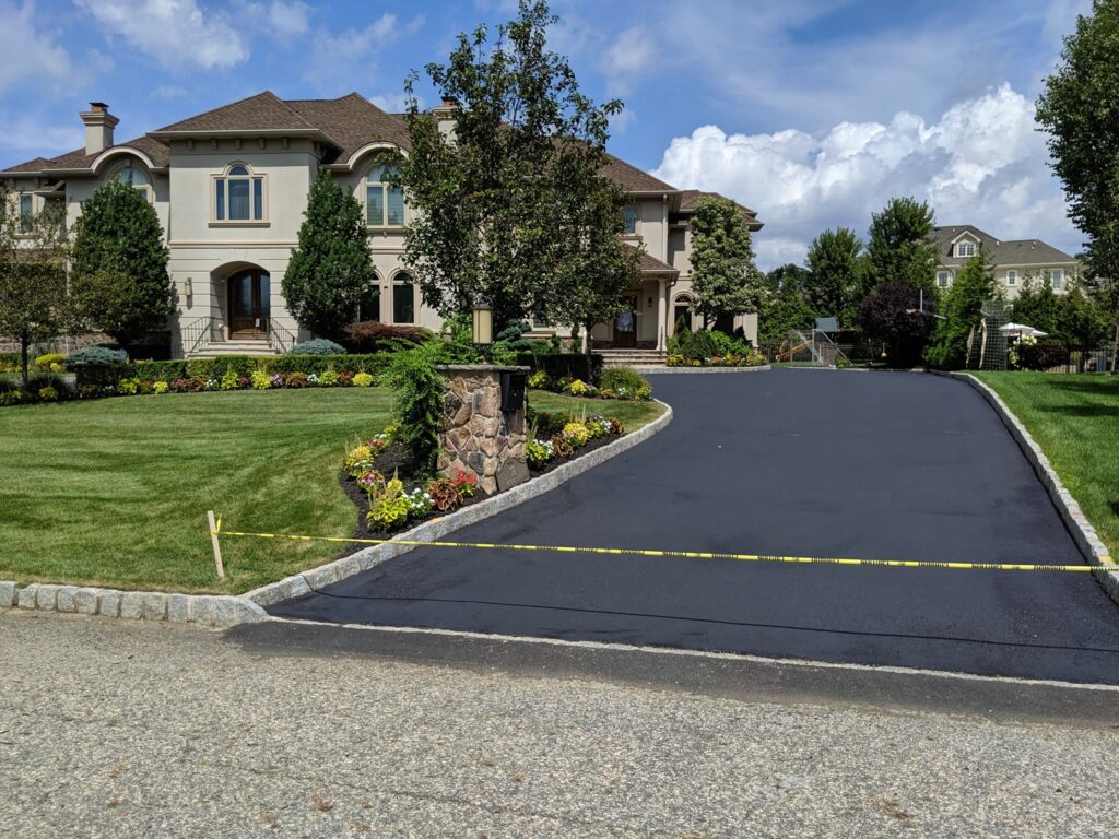 An asphalt pavement in front of a luxurious home